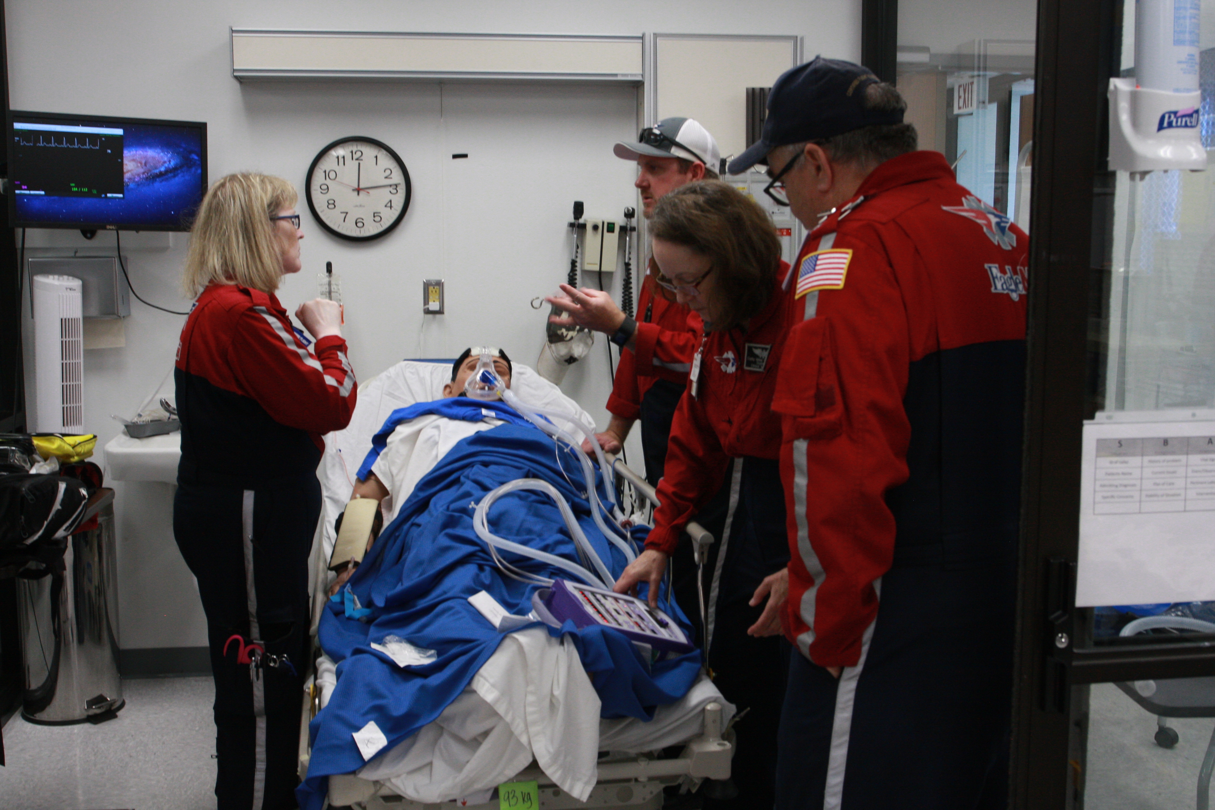 EagleMed personnel work to treat simulation mannequin in respiratory failure during quarterly training.