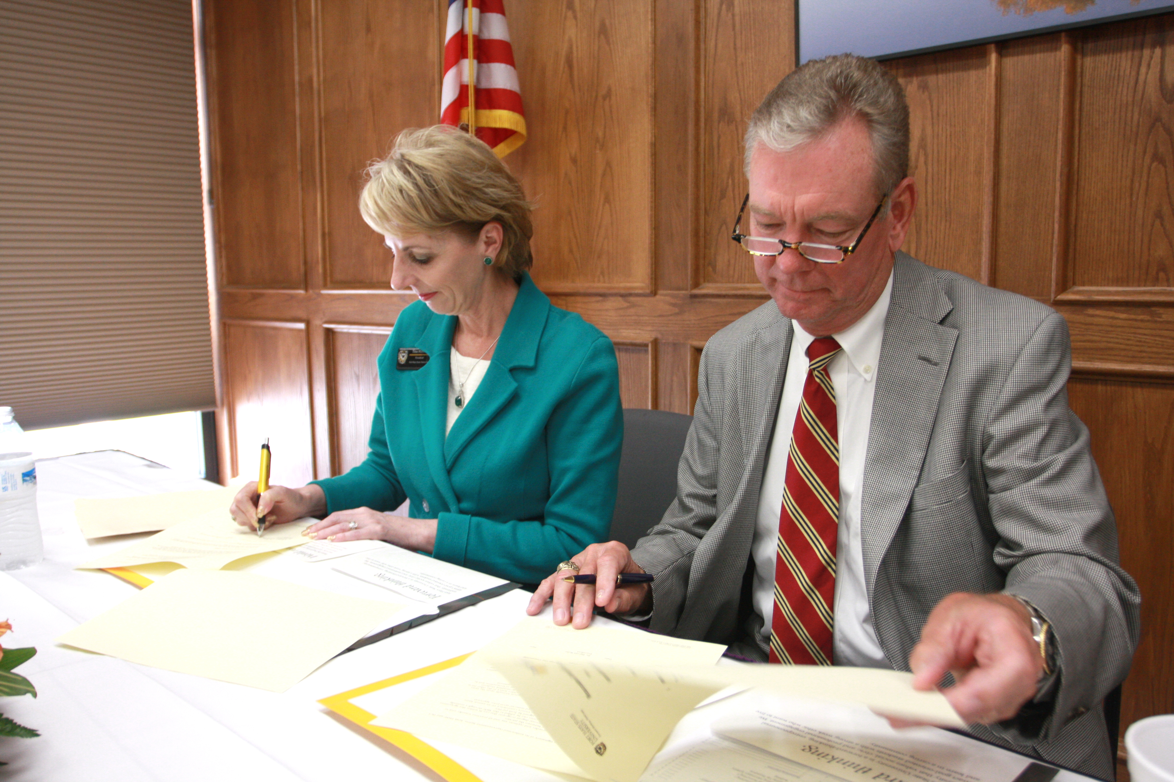 Dr. Harold Notle, president of DC3 and Dr. Tisa Mason sign the memorandum of understanding