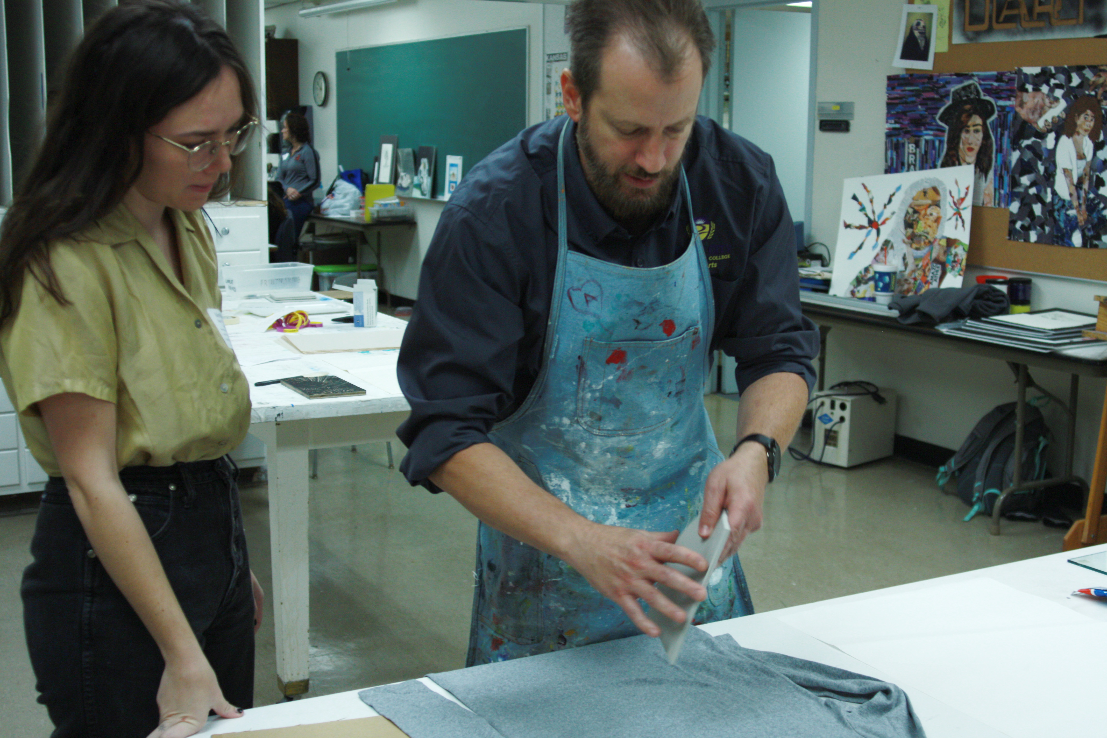 Professor Goldword demonstrates a technique for inking t-shirts for a student visiting for Sampler Day