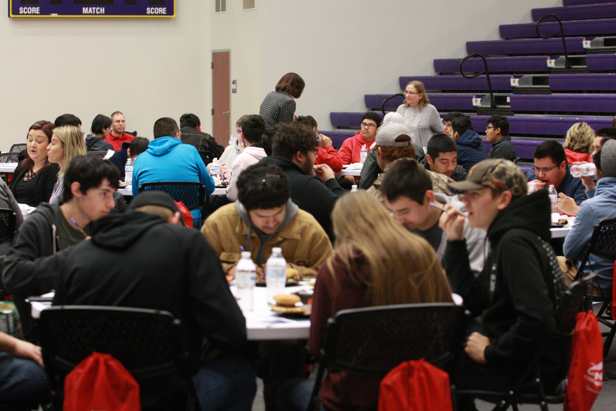 High school students completing comment cards and eating lunch at the DC3 student activity center during construction day