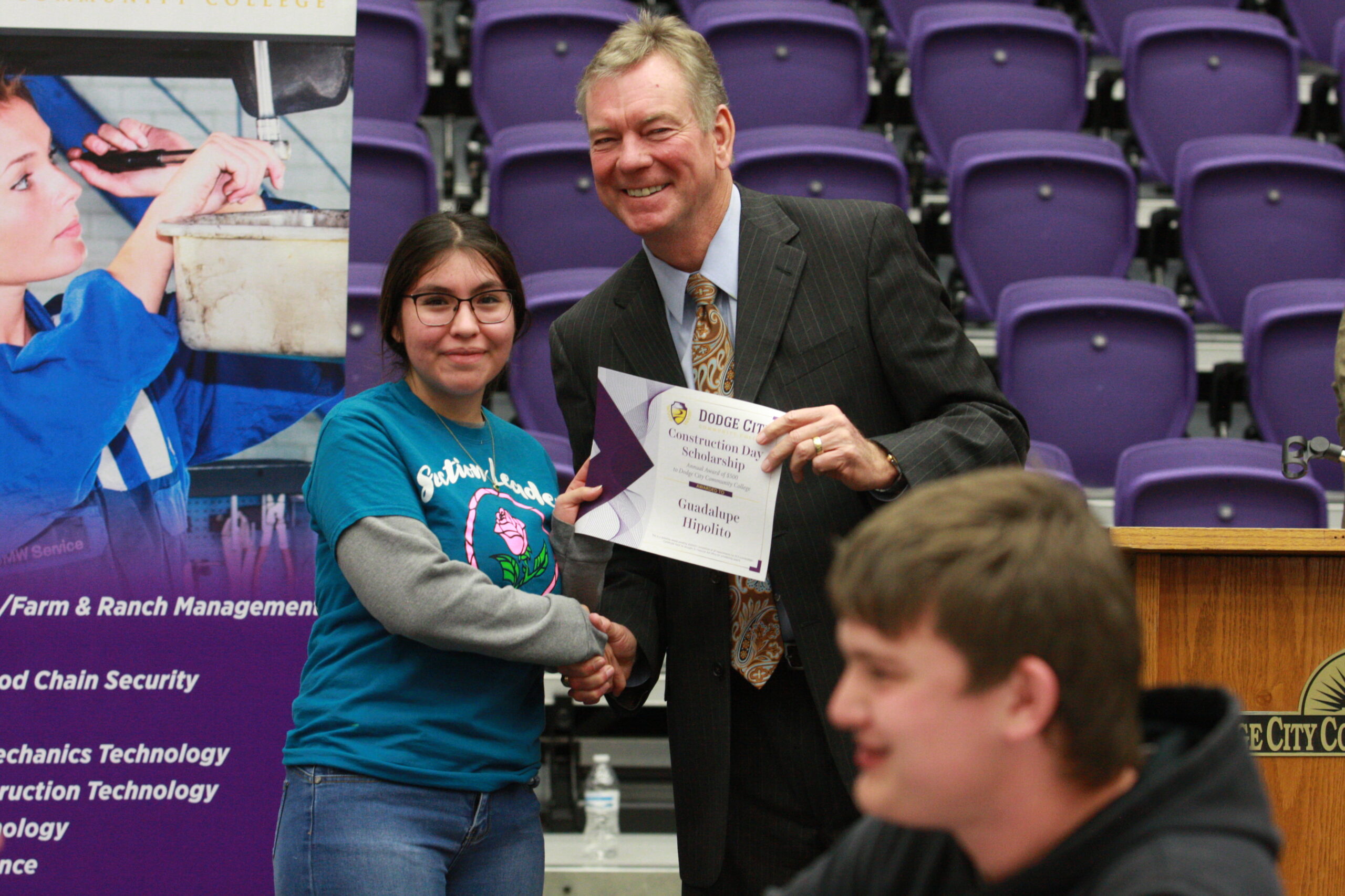 Dr. Harold Nolte, president presenting scholarship to a high school student Guadalupe Hipolito during construction day
